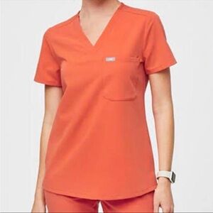 FIGS sunset orange scrubs.